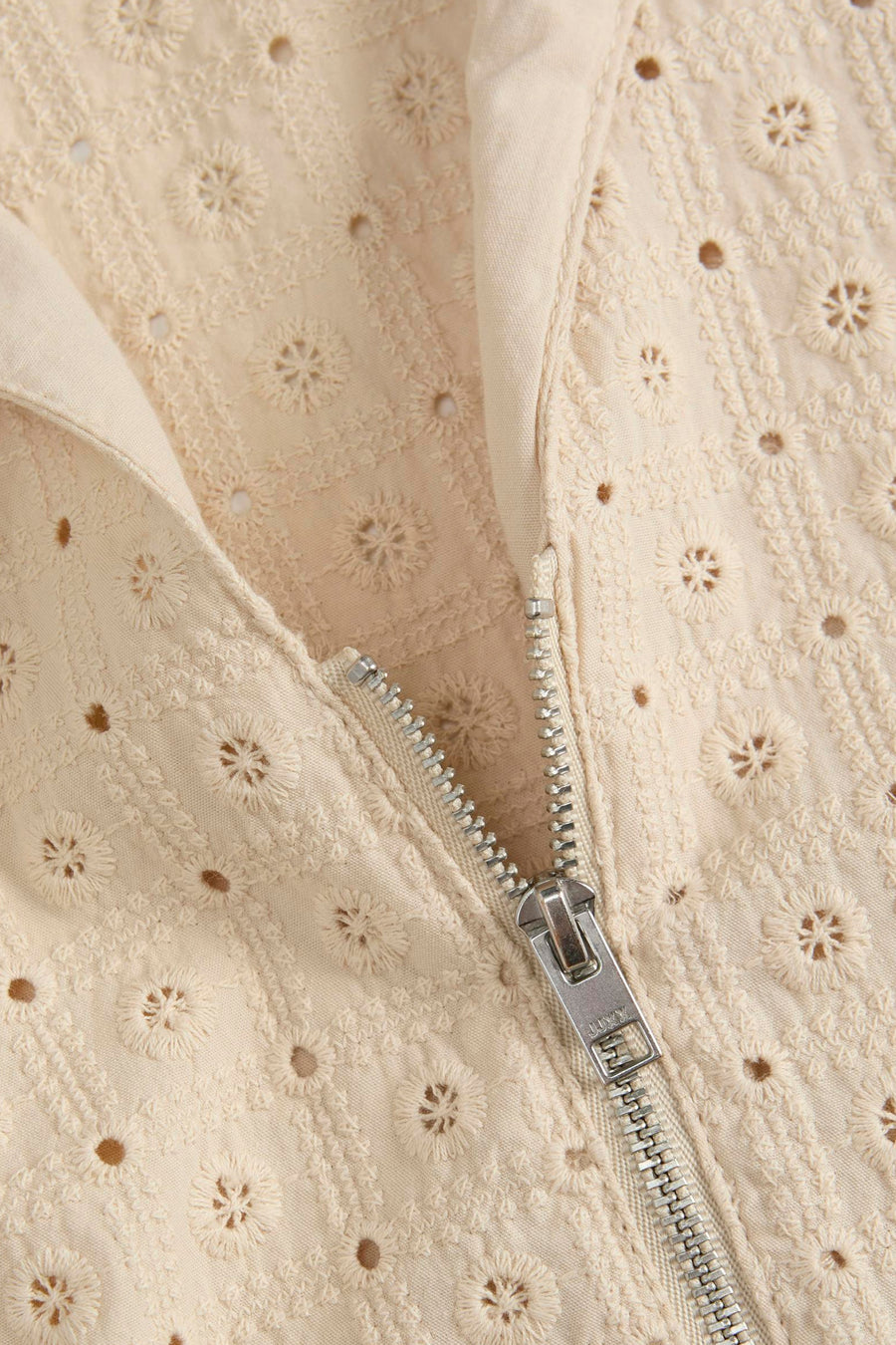 Beige blouse van JJXX met openwork details en een ritssluiting vooraan.
