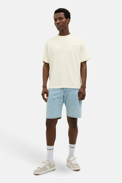 Ecru T-shirt met korte mouwen van ORIGINALS BY JACK & JONES, gedragen met denim shorts en witte sportschoenen.
