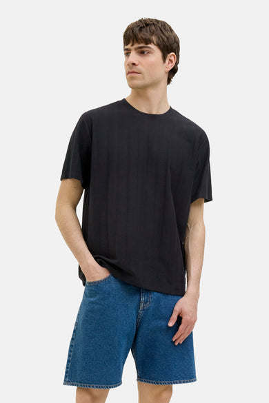 Zwart T-shirt met korte mouwen van JJREBEL, gedragen met blauwe denim shorts.
