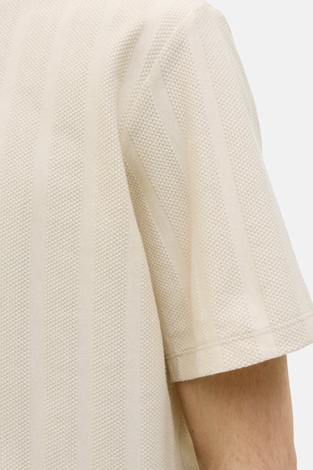 Beige T-shirt met korte mouwen van JJREBEL, met een gestreept en geweven textuur in close-up.
