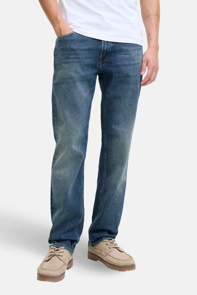 Jean droit bleu moyen en denim de JACK & JONES JEANS INTELLIGENCE, vu de dos, combiné avec un t-shirt blanc et des chaussures marron.