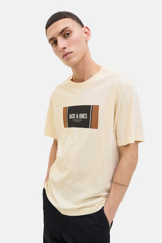 T-shirt jaune à manches courtes de CORE BY JACK & JONES, avec un logo sur la poitrine, porté avec un pantalon noir.