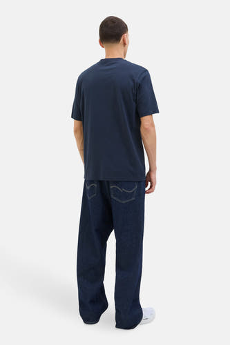 Blauw T-shirt met korte mouwen van CORE BY JACK & JONES, op een model met wijde jeans en witte sneakers.
