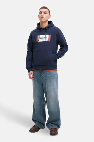 Pull-over bleu avec capuche de CORE by JACK & JONES, avec logo sur la poitrine et associé à des jeans larges.