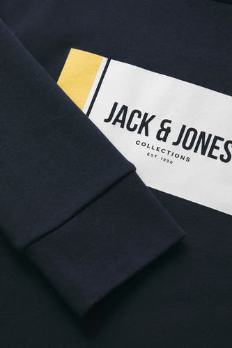 Blauwe sweater met ronde hals van CORE BY JACK & JONES, detailopname van de mouw met logo.