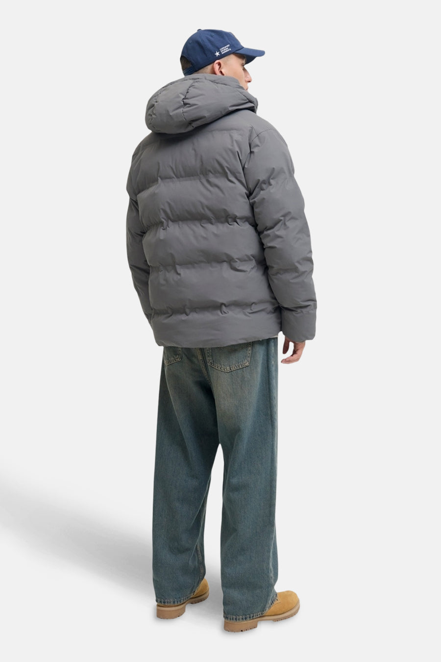 Grijs leren jas van ORIGINALS BY JACK & JONES, met capuchon en gecombineerd met losse jeans en suède laarzen.
