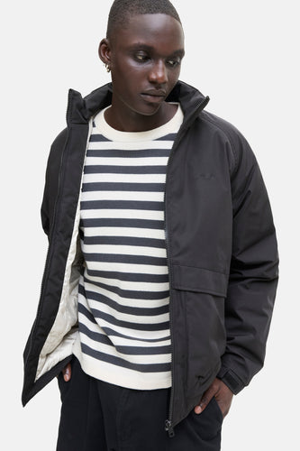 Zwarte korte jas van CORE by JACK & JONES, met gestreept shirt eronder.