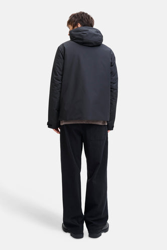 Zwarte korte jas van CORE BY JACK & JONES, gezien van achteren, met capuchon en zwarte broek.