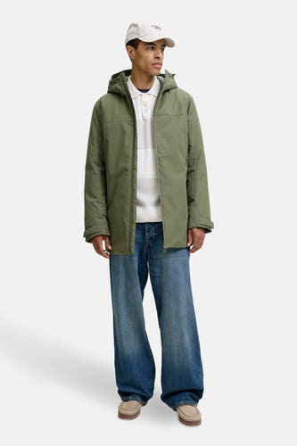 Groene korte jas van ORIGINALS BY JACK & JONES, gedragen over een wit poloshirt en wijde blauwe jeans.
