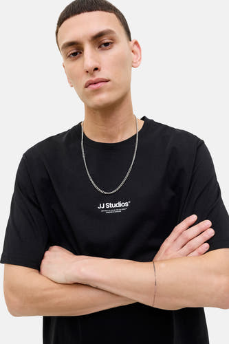 Zwart T-shirt met korte mouwen van CORE BY JACK & JONES, met een zilveren ketting en gekruiste armen.
