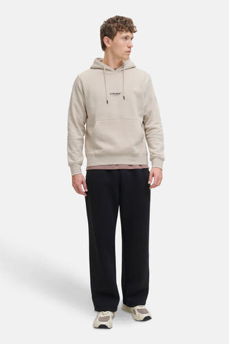 Beige sweater met kap van CORE BY JACK & JONES, gedragen met een bruin shirt en zwarte broek.