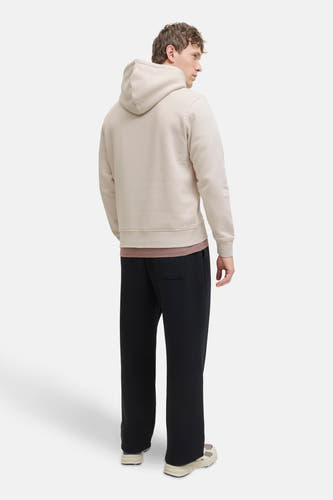 Beige sweater met kap van CORE BY JACK & JONES, gezien van achteren, met zwarte broek en crèmekleurige sneakers.
