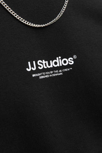 Gilet noir de CORE BY JACK & JONES avec imprimé texte blanc et une chaîne argentée.