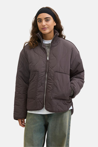Manteau court brun de JJXX, avec un motif de visière effiloché et une fermeture éclair argentée, porté sur un pull gris et des jeans bleus.