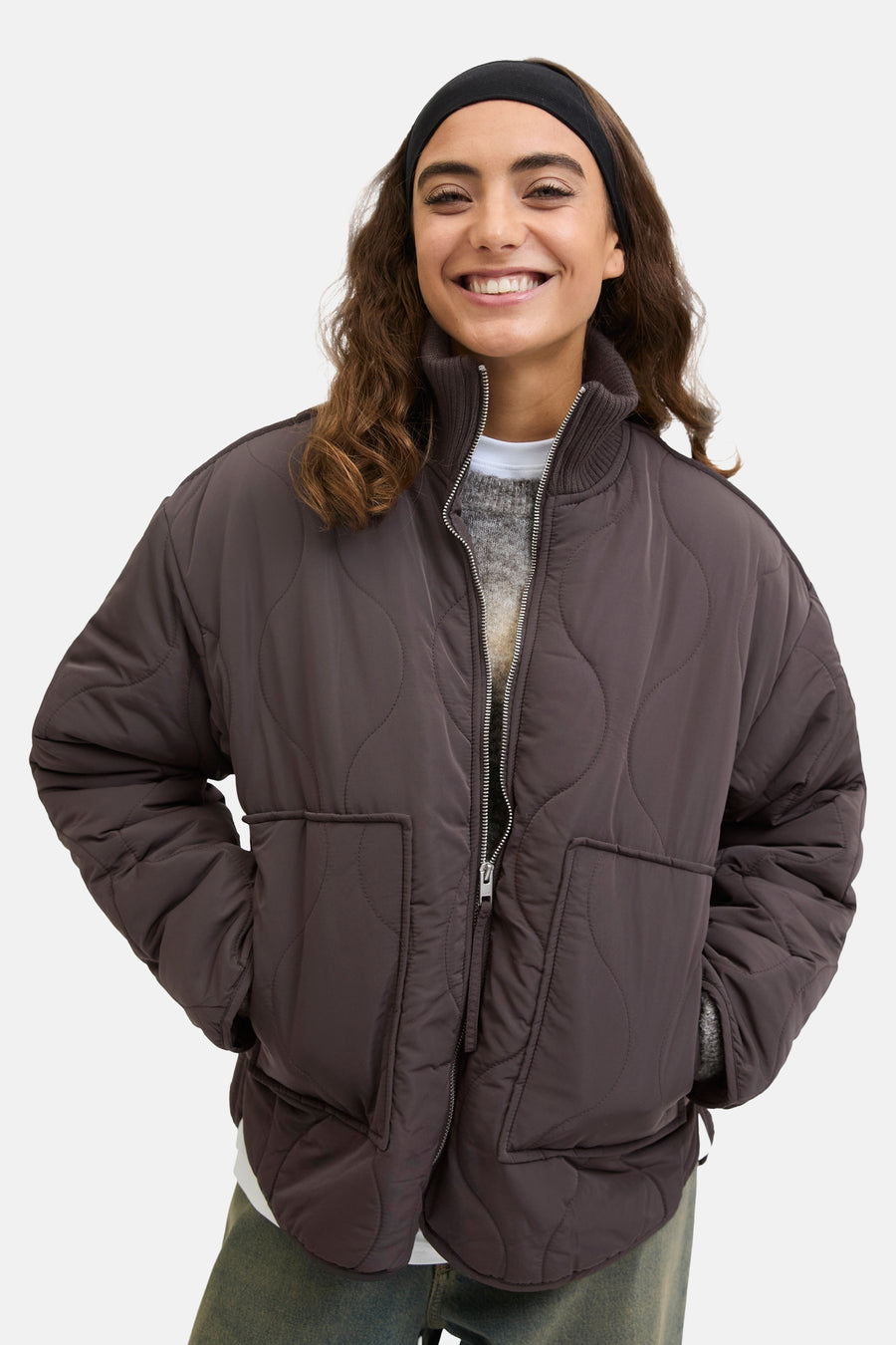 Manteau court en coton épais et gris de JJXX, avec une fermeture éclair et des poches, porté sur un pull gris avec un col blanc.