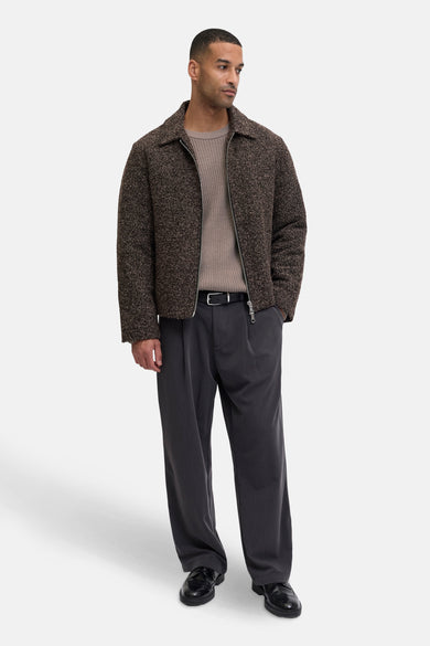 Pull beige avec col rond de PREMIUM by JACK & JONES, porté sous un manteau brun et un pantalon gris.