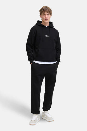 Zwarte joggingbroek van JACK & JONES JEANS INTELLIGENCE, gedragen met een witte t-shirt en witte sneakers.