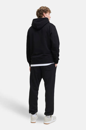 Zwarte joggingbroek van JACK & JONES JEANS INTELLIGENCE, gecombineerd met een zwarte hoodie en witte sneakers, achterkant.