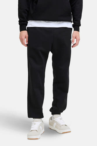 Zwarte joggingbroek van JACK & JONES JEANS INTELLIGENCE, met losse pasvorm en witte sneakers.
