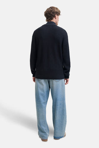 Blauwe trui van PREMIUM by JACK & JONES, met lange mouwen en grove breisteek, rugaanzicht, gecombineerd met wijde jeans.