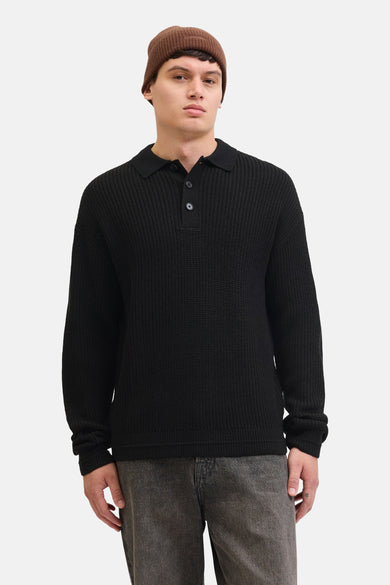 Zwarte V-hals trui van PREMIUM by JACK & JONES, met knoopsluiting en gedragen met een bruine muts.