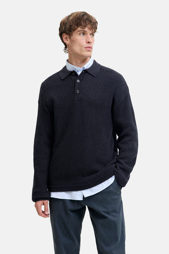 Pull-over V-hals bleu de PREMIUM by JACK & JONES, porté avec une chemise et un pantalon foncé.