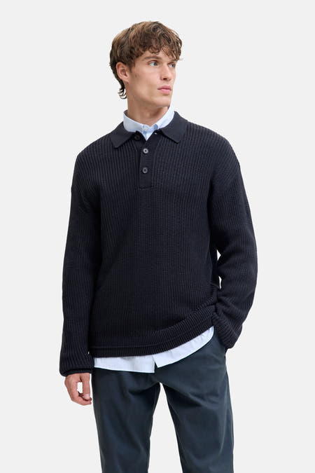 Blauwe V-hals trui van PREMIUM by JACK & JONES, met een overhemd en donkere broek.