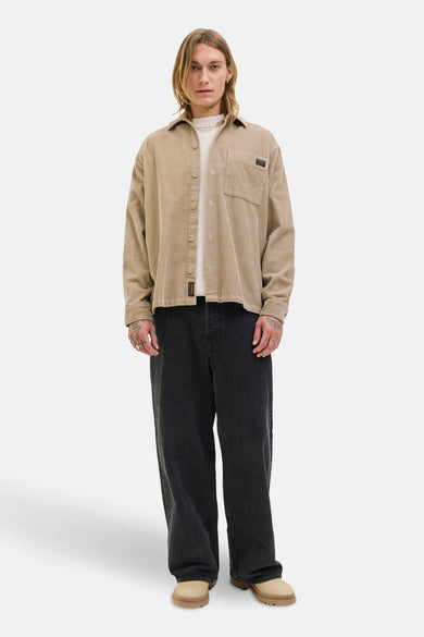Bruin overhemd met lange mouwen van PREMIUM BLUE by JACK & JONES, met knoopsluiting en borstzak, gedragen over een crèmekleurige trui.

