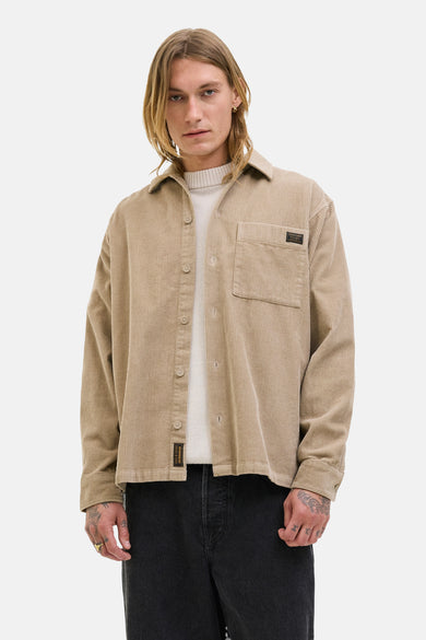 Bruin, corduroy overhemd met lange mouwen van PREMIUM BLUE by JACK & JONES, met borstzak en gedragen over een witte trui.
