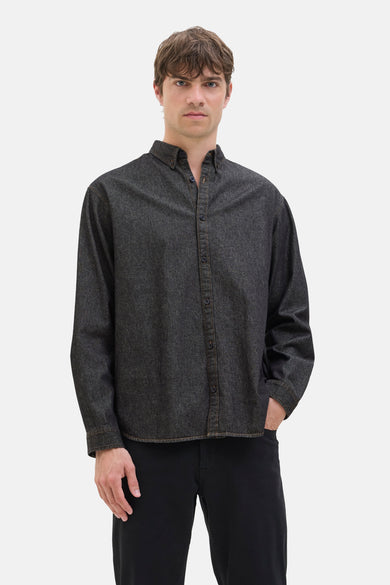 T-shirt en denim noir de JJREBEL, avec des manches longues et une fermeture à boutons, porté avec un pantalon noir.
