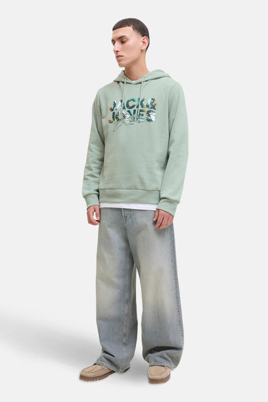 Pull vert de capimSSSS & J J J avec un im im im imé,éesées des jeans larges et des chaussures en cuir suédé.