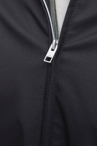 Manteau noir court de JJREBEL, avec des fermetures éclair argent et et des petites broderies.