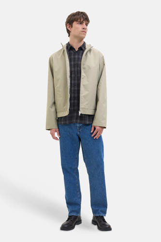 Manteau écru court de JJREBEL, associé à une chemise rayée subtile et des jeans bleus.