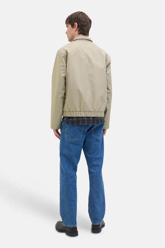 Ecru manteau court de JJREBEL, vu de derrière, avec des jeans bleus et des chaussures noires.