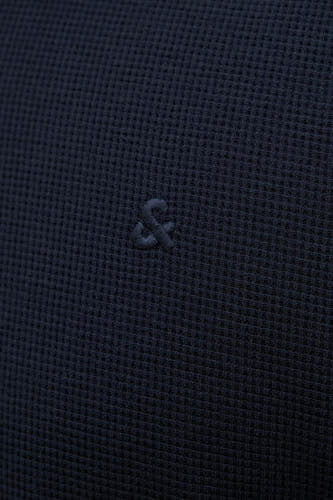 Blauwe polo van PREMIUM by JACK & JONES, met subtiel logo en wafelstructuur.