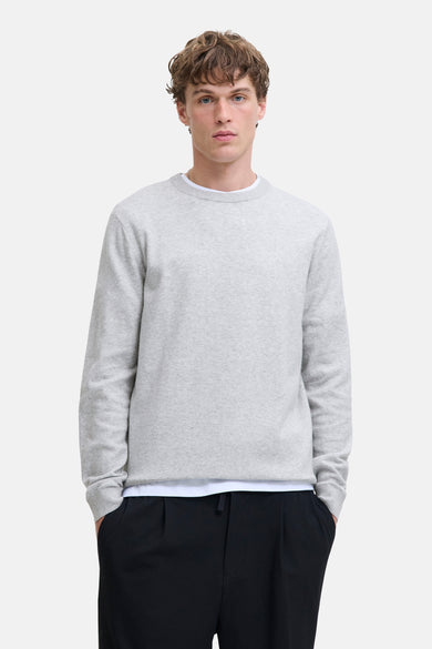 Sweat-shirt gris à col rond de PREMIUM by JACK & JONES, avec des manches longues, porté sur un shirt blanc et un pantalon noir.