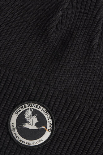 Zwarte muts van ACCESSORIES BY JACK & JONES, met geribbelde textuur en een ronde merkbadge met vogelmotief.

