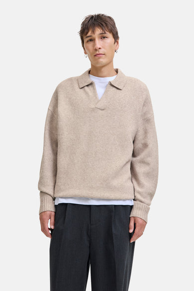 Beige V-hals trui van ORIGINALS BY JACK & JONES, gedragen over een wit T-shirt met grijze pantalon.
