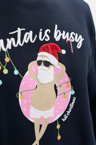 Pull-over bleu d'ORIGINALS BY JACK & JONES, avec un imprimé de Père Noël dans une bannière avec des lumières de Noël, du texte amusant et un short.