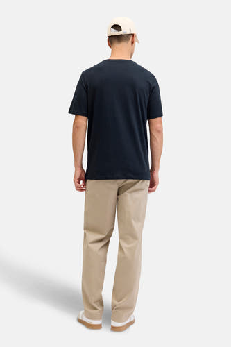 Donkerblauw T-shirt met korte mouwen van ORIGINALS BY JACK & JONES, gezien van achteren, gecombineerd met een beige broek en een pet.