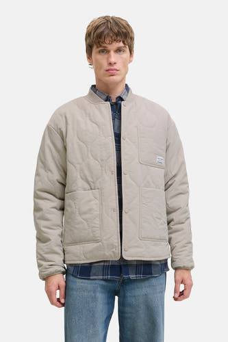 Beige korte jas van ORIGINALS BY JACK & JONES, met ruitjeshemd eronder en blauwe jeans.
