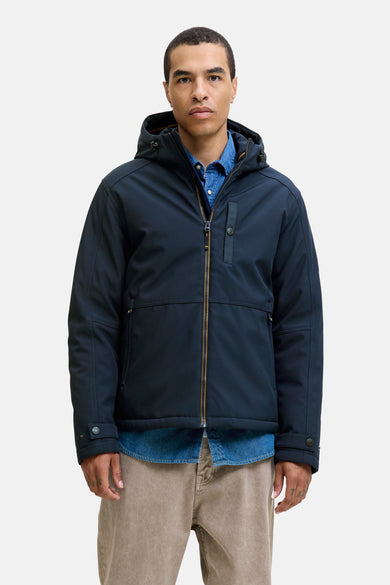 Blauwe korte jas van PREMIUM BLUE by JACK & JONES, gedragen over een denim overhemd met beige broek.

