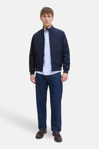 Blauwe korte jas van ORIGINALS BY JACK & JONES, gedragen over een gestreept overhemd met donkere jeans en leren schoenen.
