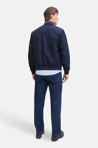 Blauwe korte jas van ORIGINALS by JACK & JONES, met gestreept overhemd en donkere jeans.
