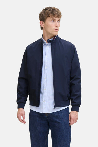 Korte blauwe jas van ORIGINALS BY JACK & JONES, met rits en gedragen over een gestreept overhemd en donkere jeans.
