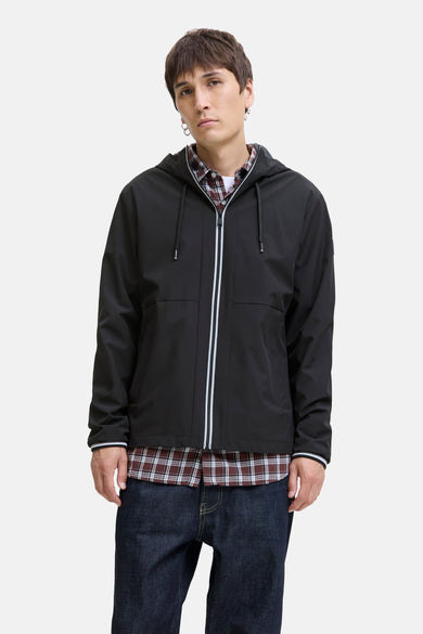 Manteau court noir d'ORIGINALS BY JACK & JONES, avec capuche, fermeture éclair avec des accents blancs et des jeans noirs.