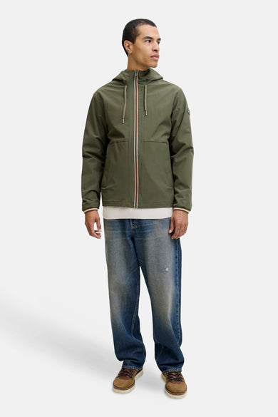 Courte veste verte d'ORIGINALS BY JACK & JONES, portée avec un pull blanc, des jeans larges et des chaussures marron.
