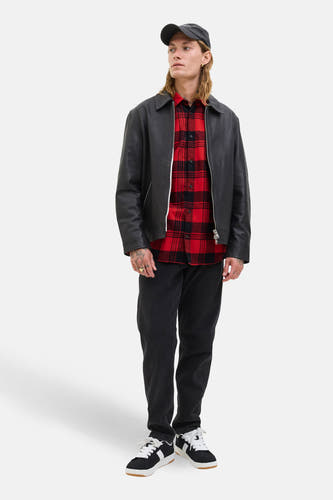 Rood overhemd met lange mouwen van PREMIUM BLUE by JACK & JONES, met een zwart-rood ruitpatroon, gedragen met een zwarte leren jas en pet.
