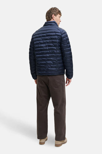 Blauwe korte jas van PREMIUM BLUE by JACK & JONES, met horizontale stiksels, gedragen met bruine broek en suède schoenen.
