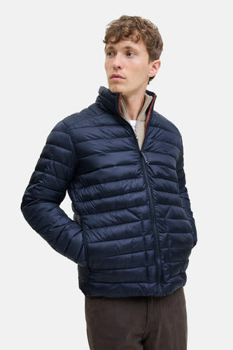 Korte blauwe jas van PREMIUM BLUE by JACK & JONES, met gewatteerd ontwerp en rits aan de voorkant, gedragen over een trui.
